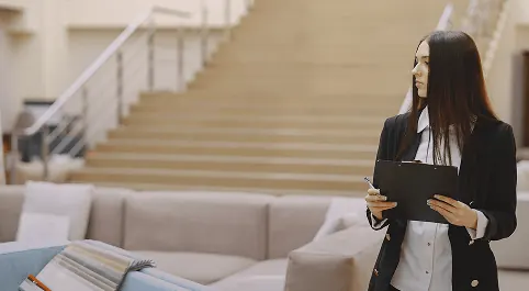 Cheffe de service avec un porte-bloc dans le hall d'un hôtel