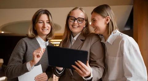 Équipe hôtelière réunie autour d'une tablette dans un lobby